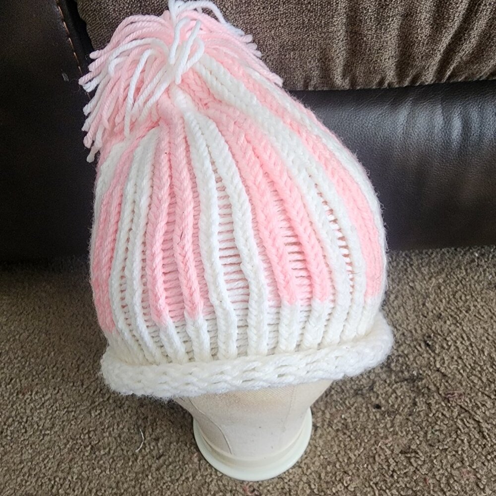This is a custom  women's handmade light pink and white knitted pompom hat